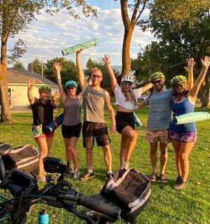 a group of people standing in the grass with their hands in the air