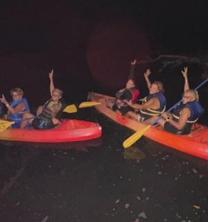 夜晚，一群孩子在水上划皮艇