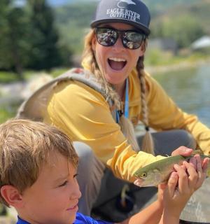 一名妇女和一名小男孩拿着一条鱼