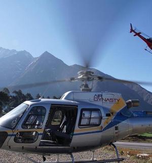 一架直升机停在跑道上，背景是群山