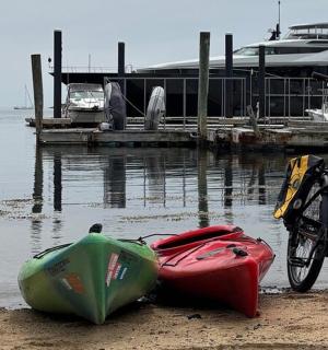 停在海滩上的一辆自行车和一艘皮划艇