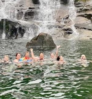 一群人在瀑布附近的水中游泳