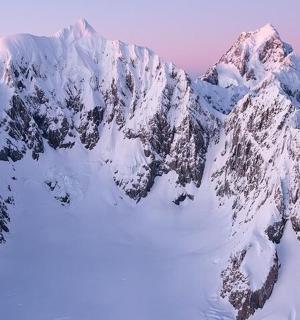 a mountain covered in snow with the sky in the background