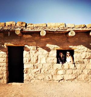 a bride and groom standing in the window of a building