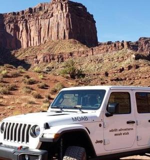 a white jeep parked in the desert