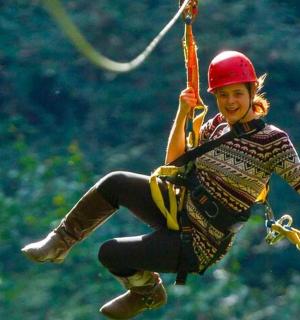 eine Frau, die an einem Seil an einer Seilrutsche hängt