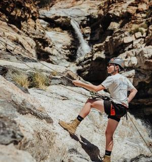 Muž je na skalnaté hoře s lanem