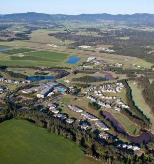 Loftmynd af almenningsgarði með húsum og vatni