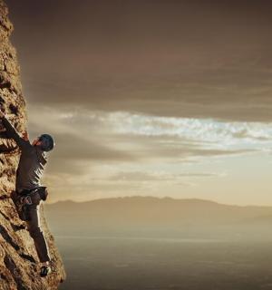 muž leze na útes na hoře