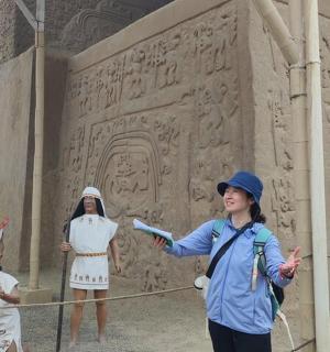 a group of people standing in front of a wall with a statue