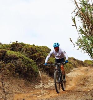 一名男子骑着自行车沿着土路行驶