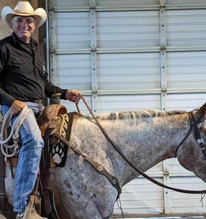 a man in a cowboy hat sitting on a horse