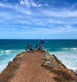 一名男子站在码头上,带着两辆自行车