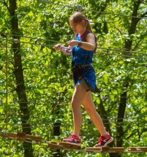 一个女孩在绳索公园散步