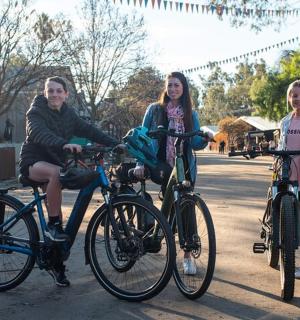 一名男子和两名女孩在街上骑自行车
