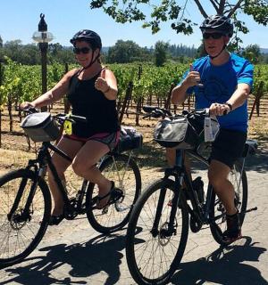 两个人在葡萄园前骑自行车