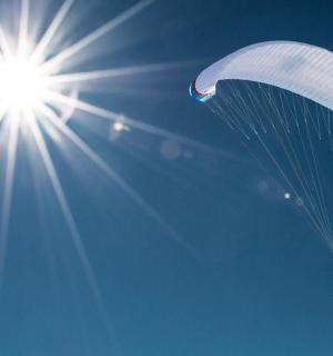 a person flying in the sky with a parachute