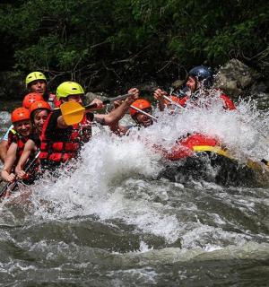 一群人坐在河里的木筏上