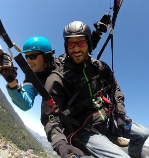 two people are riding on a tandem parachute