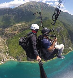 two people are riding a parachute over the water