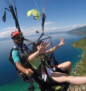 a person is hanging from a parachute over a lake