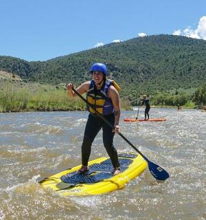 osoba jedoucí na paddleboardu na řece