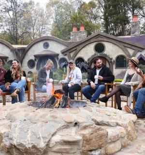 skupina lidí sedících kolem ohniště