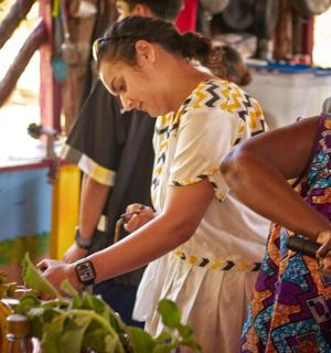 two women standing in a market looking at produce
