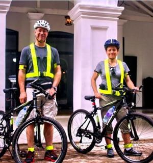 two men in yellow vests standing with their bikes