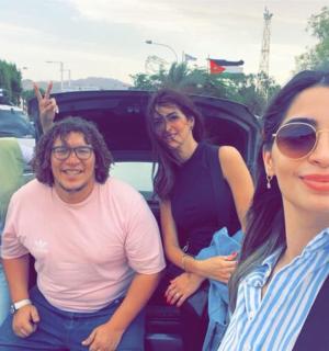 a group of people standing in front of a car