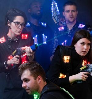 a group of people standing around a woman holding a gun