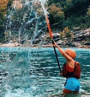 一个人站在水中，手里拿着水管