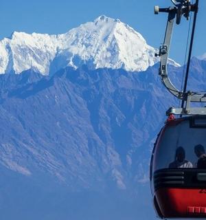 一群人乘坐滑雪缆车在山前