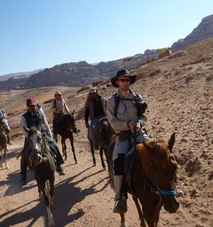 skupina lidí jezdících na koních na hoře