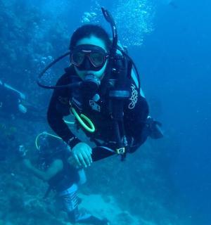 穿着潜水服和护目镜在海里游泳的人