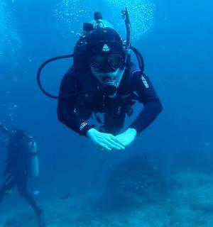 一名身穿潜水服的男子在海里游泳