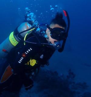 一名身穿潜水服的男子正在海里游泳