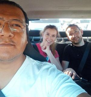 三个人坐在汽车后座