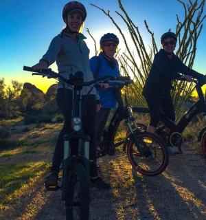 三个男孩骑着自行车在土路上行驶