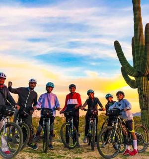 一群人骑着自行车停在仙人掌前