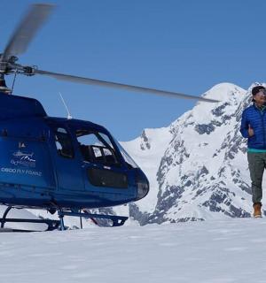 a man standing next to a helicopter in the snow