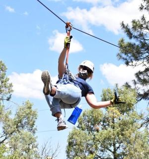 muž visící na zip laně