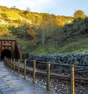 ein Tunnel in einem Hügel mit einem Zug