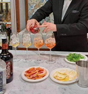 a man in a suit pouring wine into wine glasses