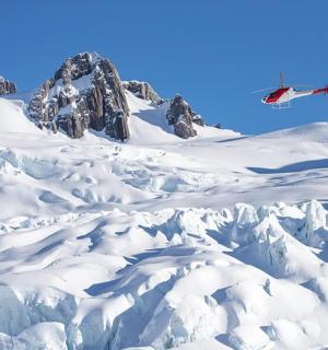 a kite is flying over a snow covered mountain