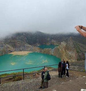 a man standing on the edge of a mountain taking a picture
