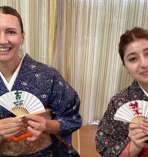 two women are posing for a picture while holding food
