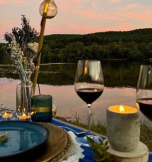 a table with two glasses of wine and a candle