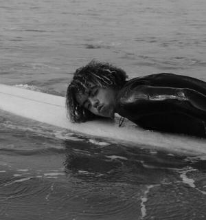 a woman laying on a surfboard in the water