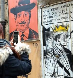 a woman taking a picture of a poster of a man
